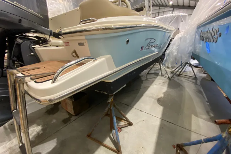 Slide: The Image of 2019 Pioneer 202 Islander boat in storage, showcasing rear deck and motor. - 5