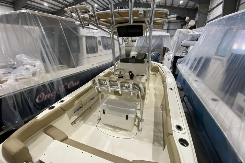 Slide: The Image of 2019 Pioneer 202 Islander boat in storage, featuring a clean interior and fishing rod holders. - 8