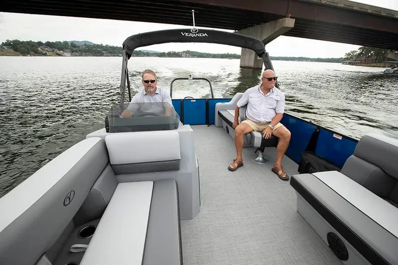 Slide: The Image of 2024 Veranda Luxury Pontoons Vista 22 RC cruising under a bridge with two passengers. - 3