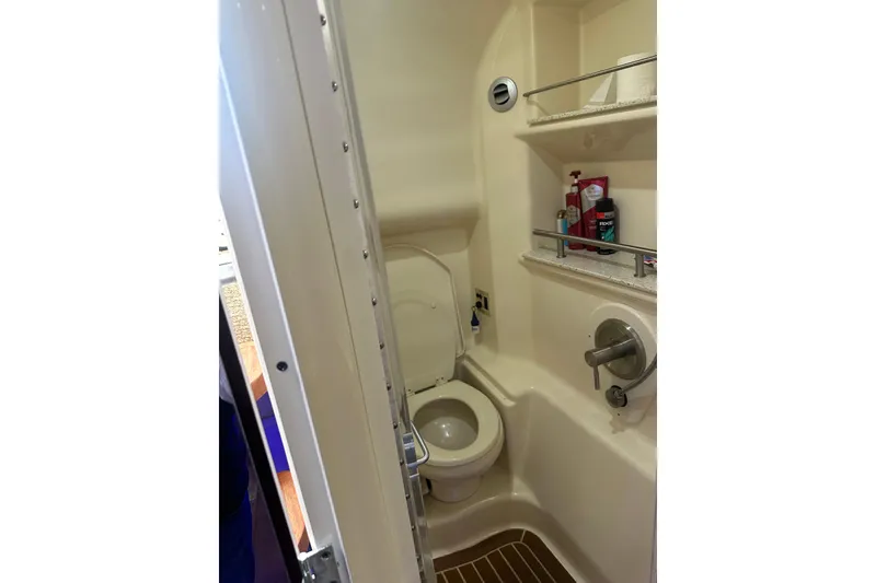 Slide: The Image of Bathroom interior of 2016 Searay Sundancer 370 yacht, featuring toilet and shelves. - 14