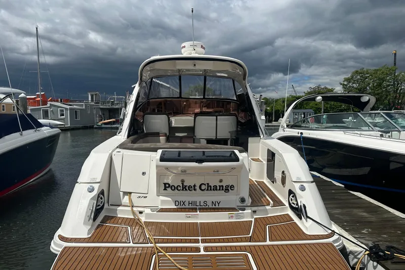 Slide: The Image of 2016 Searay Sundancer 370 yacht docked, named "Pocket Change," under cloudy skies. - 2