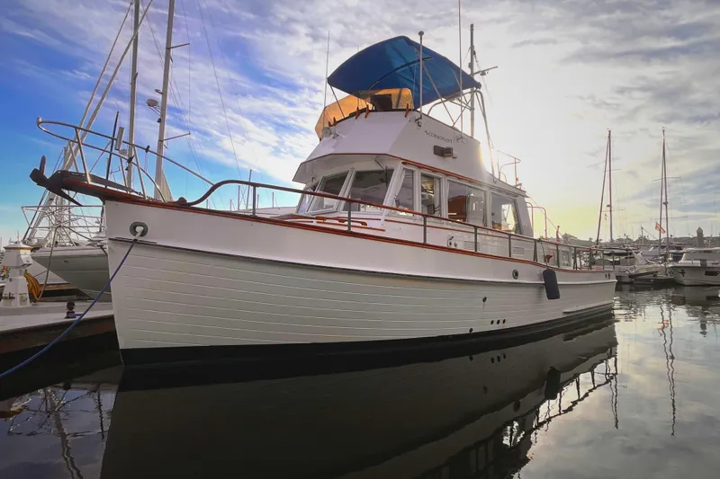 The Image of 1979 Grand Banks 36 Classic yacht docked at marina, under a cloudy sky. - 0