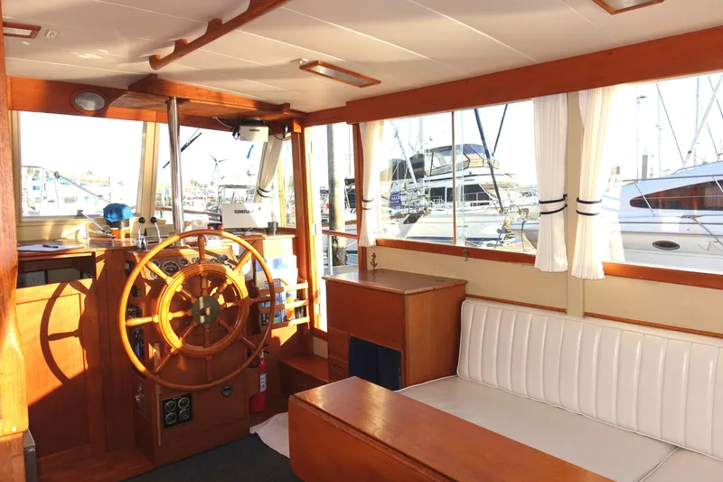 Slide: The Image of Interior of 1979 Grand Banks 36 Classic boat with wooden helm and white seating. - 17