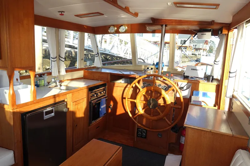Slide: The Image of 1979 Grand Banks 36 Classic boat interior with wooden helm, kitchen, and navigation equipment. - 18