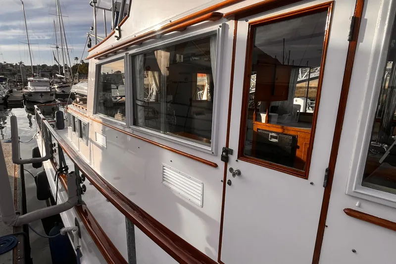 Slide: The Image of 1979 Grand Banks 36 Classic yacht docked, showcasing elegant wood trim and spacious windows. - 24