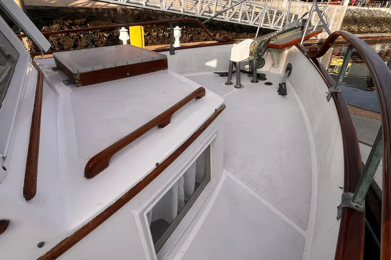 Slide: The Image of 1979 Grand Banks 36 Classic boat deck with wooden railings and winch. - 25