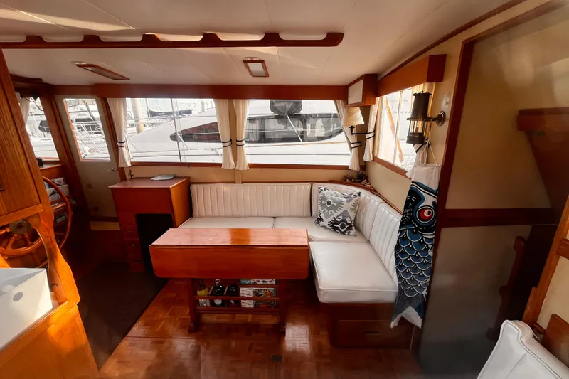 Slide: The Image of 1979 Grand Banks 36 Classic yacht interior with wooden accents and white seating. - 36