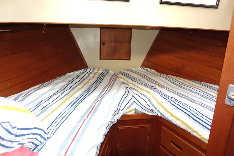 Slide: The Image of 1979 Grand Banks 36 Classic cabin with twin beds and striped bedding. - 37
