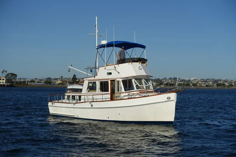Slide: The Image of 1979 Grand Banks 36 Classic yacht cruising on calm waters under clear blue sky. - 5