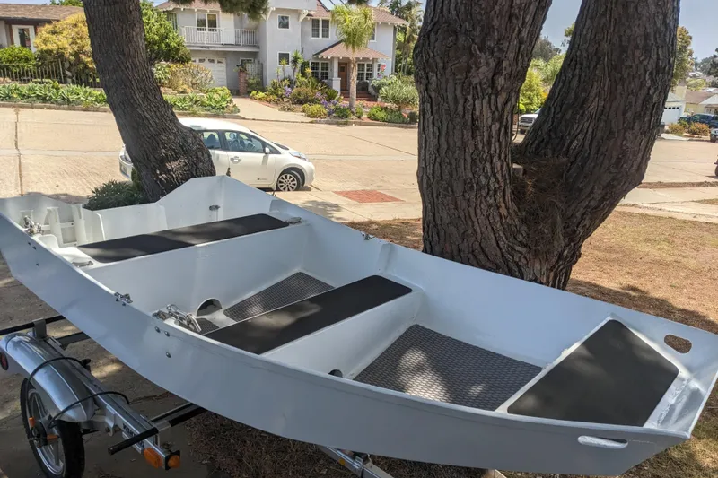 Slide: The Image of White boat on trailer, parked near trees in residential area. - 54