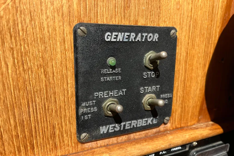 Slide: The Image of Control panel of a 1979 Grand Banks 36 Classic generator with switches and labels. - 59