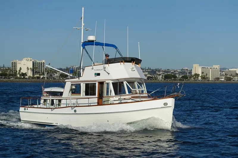 Slide: The Image of 1979 Grand Banks 36 Classic yacht cruising on blue water near city skyline. - 7