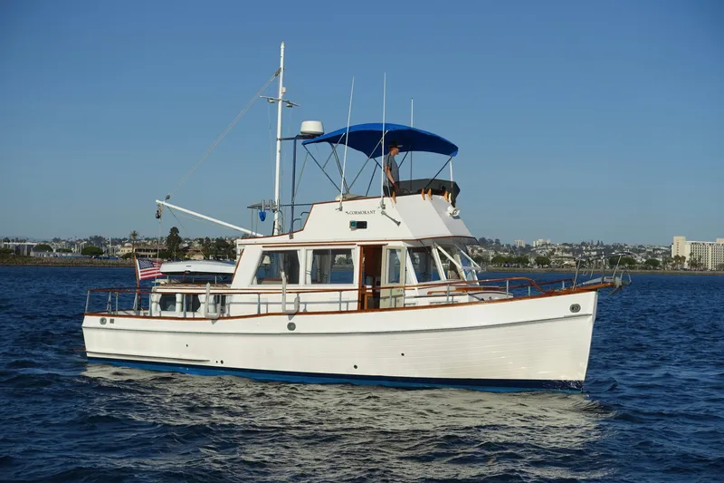 Slide: The Image of 1979 Grand Banks 36 Classic yacht cruising on calm waters under clear blue skies. - 9
