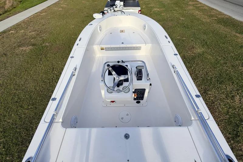 Slide: The Image of 2015 Pioneer 186 Cape Island boat, white interior, steering console, parked on grass. - 47