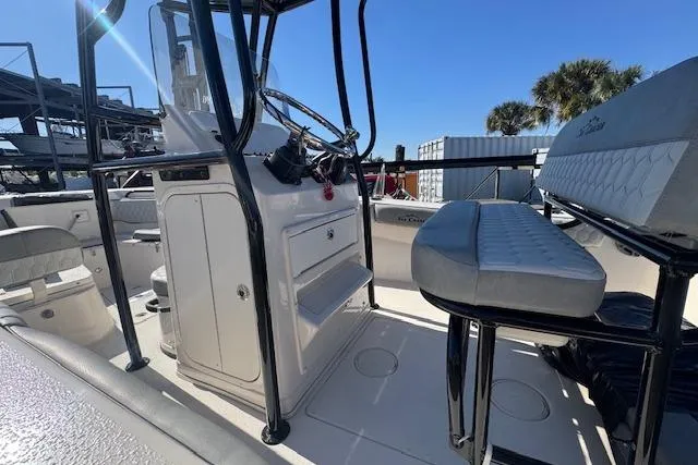 Slide: The Image of 2026 Sea Chaser 22 HFC boat interior with steering console and seating, under clear blue sky. - 7