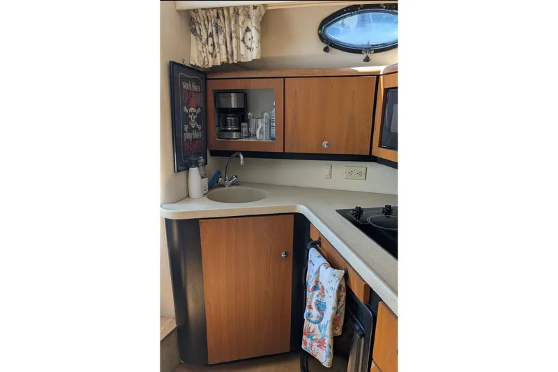 Slide: The Image of 1998 Wellcraft 3600 Martinique yacht kitchen with wooden cabinets and modern appliances. - 6