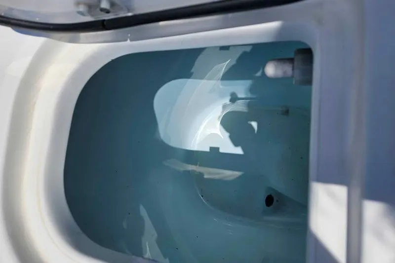 Slide: The Image of 2019 Robalo R247 Dual Console boat interior compartment with water reflection. - 18