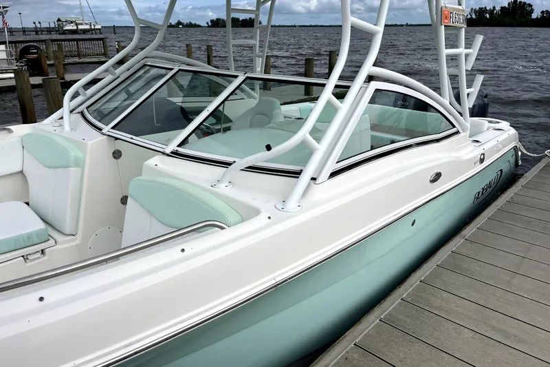 Slide: The Image of 2019 Robalo R247 Dual Console boat docked by the water. - 19