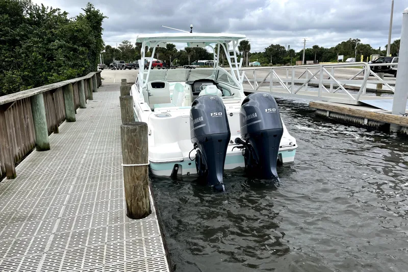 Slide: The Image of 2019 Robalo R247 Dual Console boat docked with twin Yamaha 150 engines. - 20