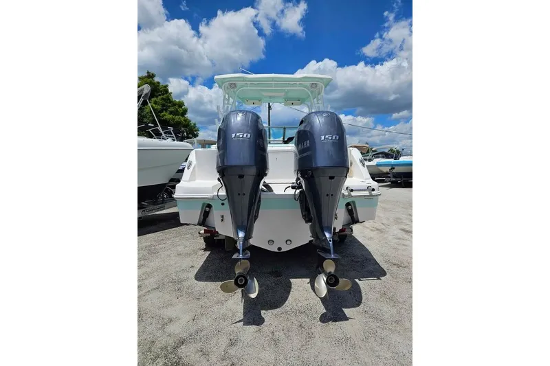 Slide: The Image of 2019 Robalo R247 Dual Console boat with twin Yamaha 150 engines, parked outdoors. - 3