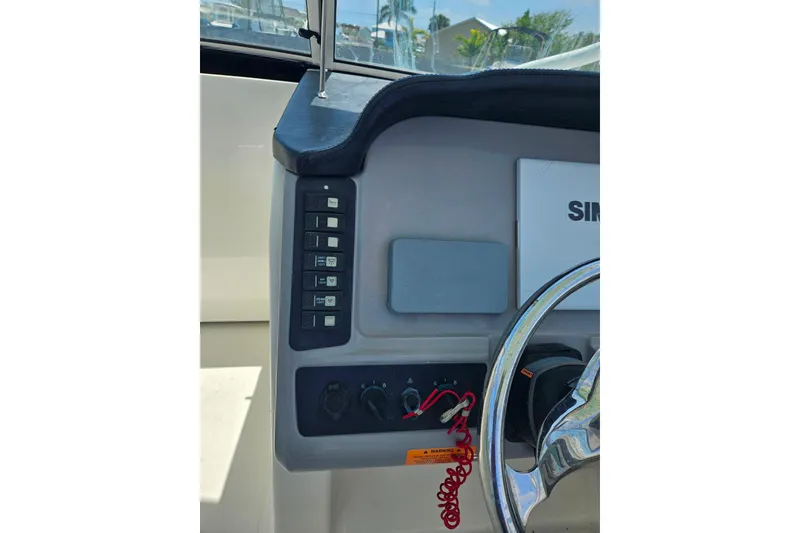 Slide: The Image of 2019 Robalo R247 Dual Console dashboard with controls and steering wheel. - 31
