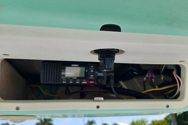 Slide: The Image of 2019 Robalo R247 Dual Console boat radio compartment with wiring and equipment. - 32