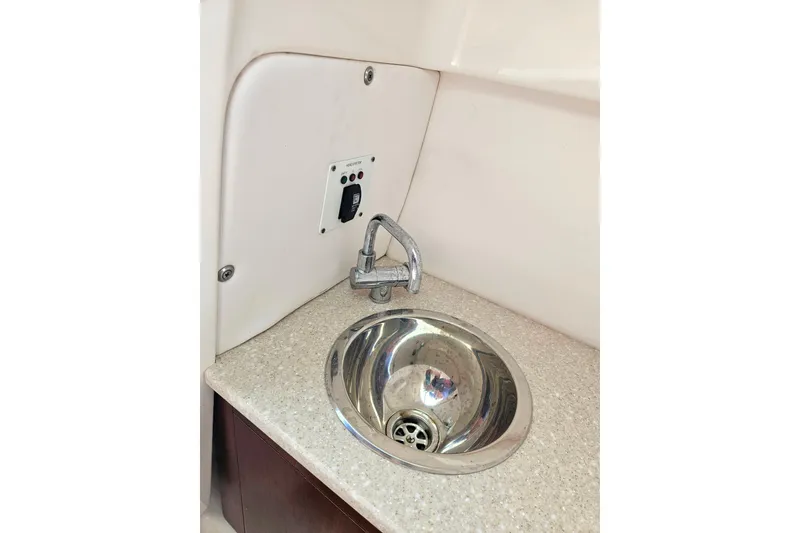 Slide: The Image of 2019 Robalo R247 Dual Console boat sink with faucet and control panel. - 33