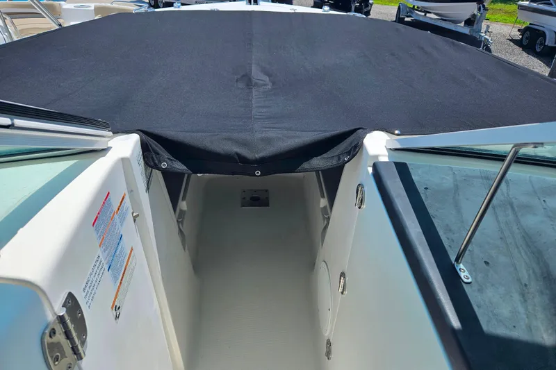Slide: The Image of 2019 Robalo R247 Dual Console boat with black cover, interior view. - 35