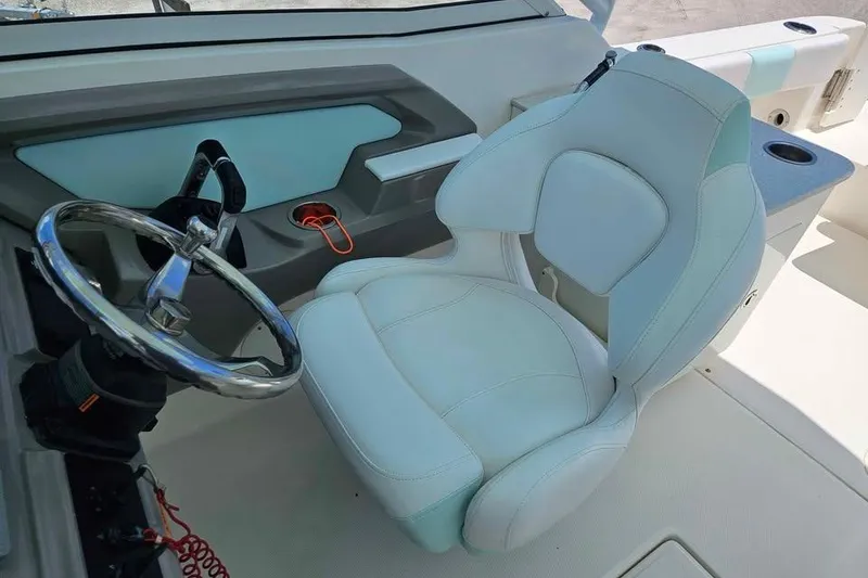 Slide: The Image of 2019 Robalo R247 Dual Console boat interior with steering wheel and captain's seat. - 6