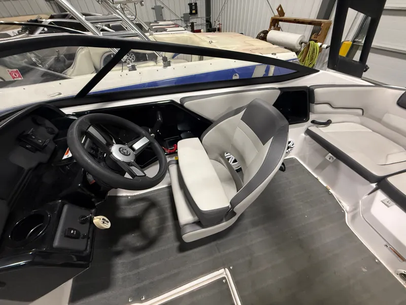 Slide: The Image of Interior view of a modern boat with gray and white seating and a black steering wheel. - 18