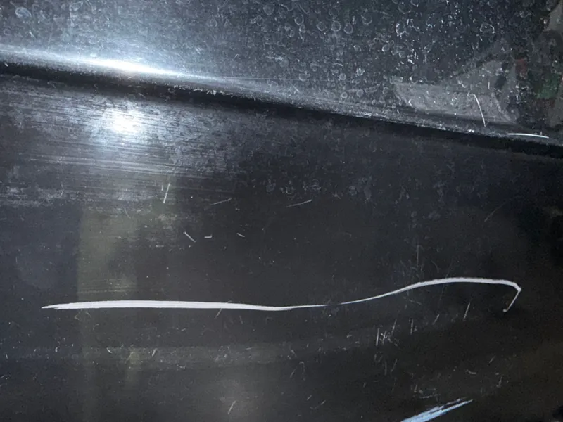 Slide: The Image of Close-up of a black boat hull with scratches. - 26