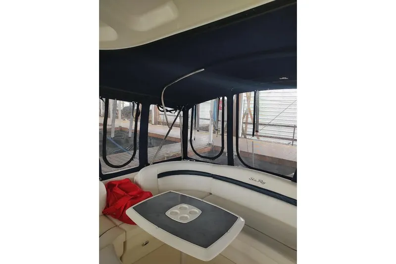 Slide: The Image of 2005 Sea Ray 390 Sundancer interior with seating and table, featuring enclosed windows. - 3
