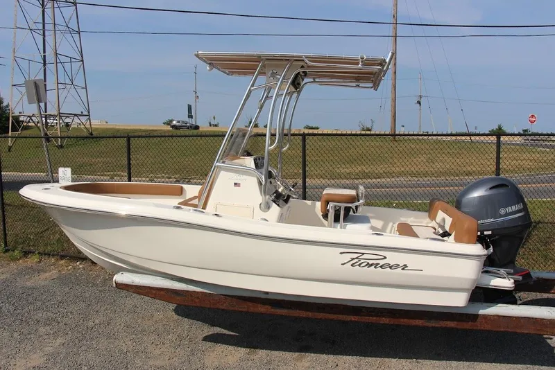 Slide: The Image of 2025 Pioneer 180 Islander boat with Yamaha engine, parked on a trailer. - 2