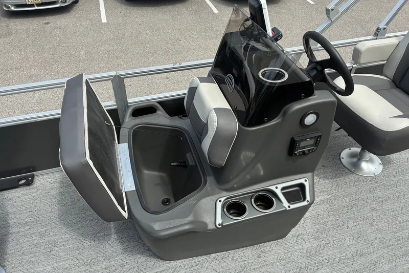 Slide: The Image of 2026 Sun Tracker Bass Buggy 18 DLX boat console with storage, steering wheel, and cup holders. - 13