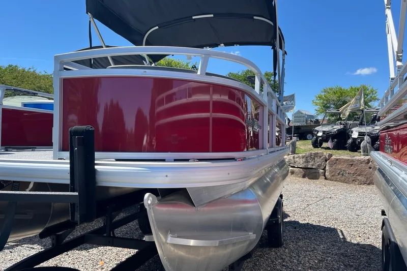 Slide: The Image of 2026 Sun Tracker Bass Buggy 18 DLX pontoon boat with red exterior, parked outdoors. - 1