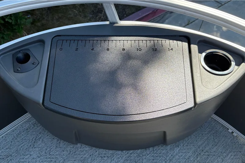 Slide: The Image of 2026 Sun Tracker Bass Buggy 18 DLX boat console with ruler and cup holders. - 43