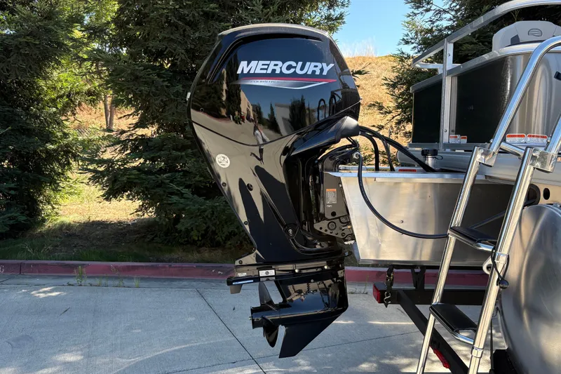 Slide: The Image of 2026 Sun Tracker Bass Buggy 18 DLX with Mercury outboard motor, parked outdoors. - 35