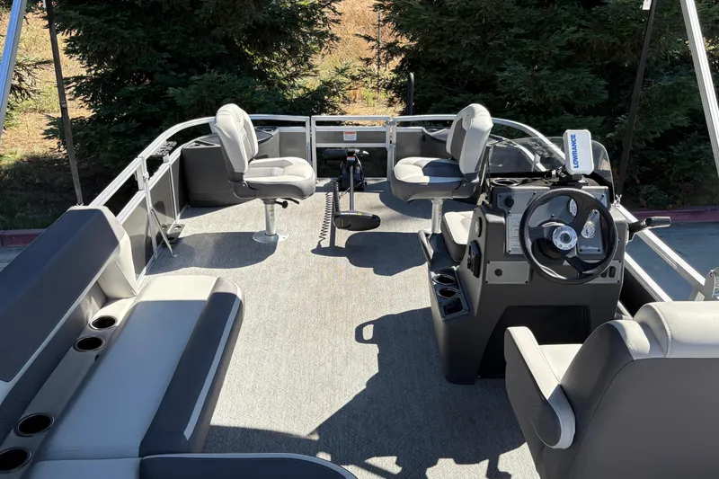 Slide: The Image of 2026 Sun Tracker Bass Buggy 18 DLX pontoon boat interior with seating and steering console. - 18