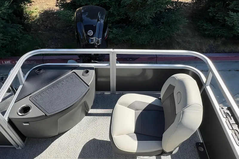 Slide: The Image of 2026 Sun Tracker Bass Buggy 18 DLX pontoon boat interior with seating and motor view. - 23