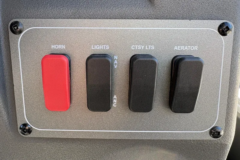 Slide: The Image of Control panel of 2026 Sun Tracker Bass Buggy 18 DLX with switches for horn, lights, and aerator. - 16