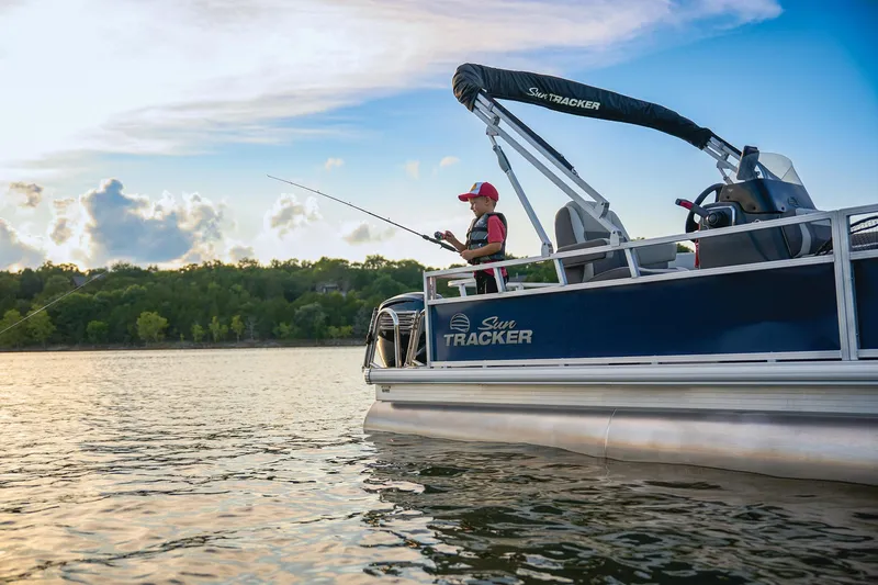 Slide: The Image of 2026 Sun Tracker Bass Buggy 18 DLX pontoon boat interior with seating and steering wheel. - 11