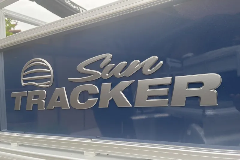 Slide: The Image of Sun Tracker logo on 2026 Bass Buggy 18 DLX boat, metallic lettering on blue background. - 80