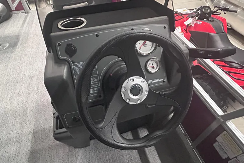 Slide: The Image of Steering console of 2026 Sun Tracker Bass Buggy 18 DLX with gauges and cup holder. - 15