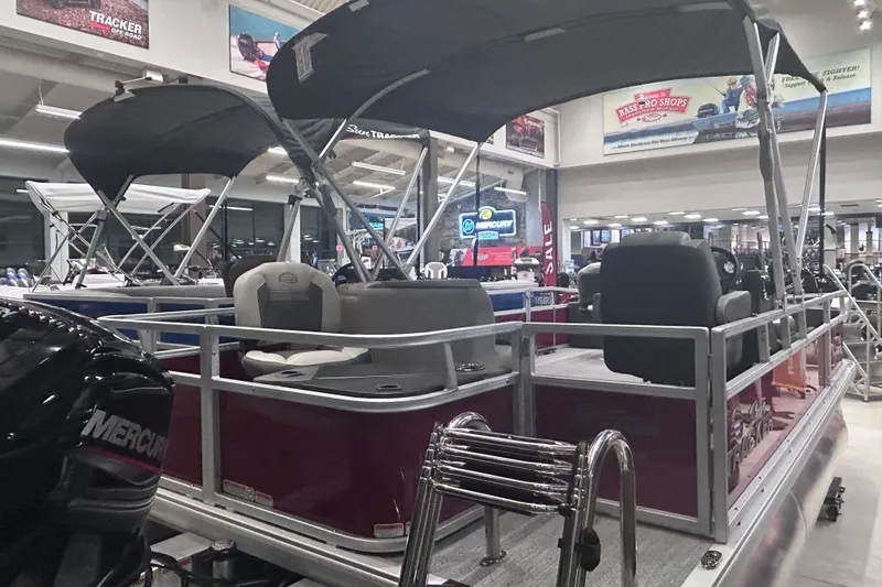Slide: The Image of 2026 Sun Tracker Bass Buggy 18 DLX pontoon boat displayed indoors. - 3