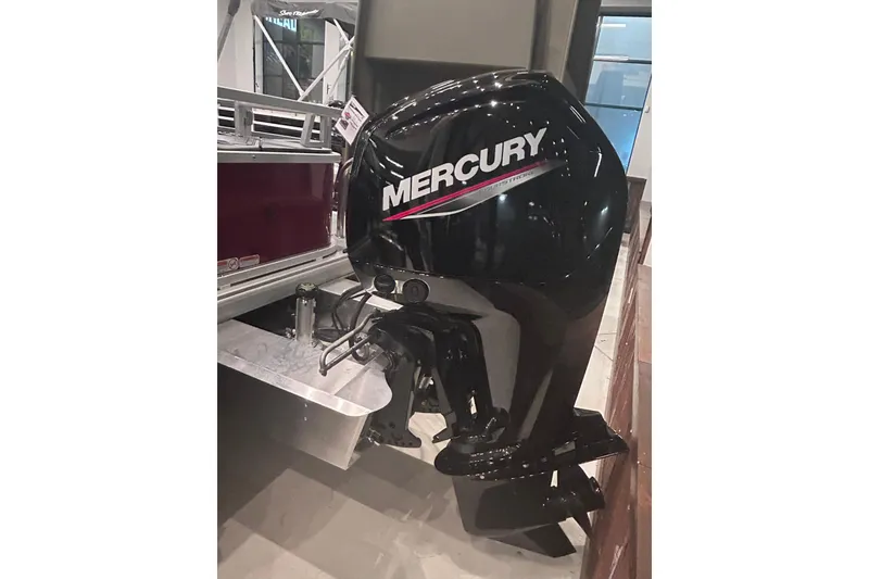 Slide: The Image of 2026 Sun Tracker Bass Buggy 18 DLX with Mercury outboard motor, displayed indoors. - 5