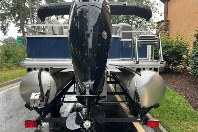 Slide: The Image of 2026 Sun Tracker Bass Buggy 18 DLX pontoon boat, rear view with motor and trailer. - 3