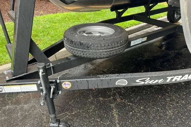 Slide: The Image of Trailer of 2026 Sun Tracker Bass Buggy 18 DLX with spare tire on wet pavement. - 9
