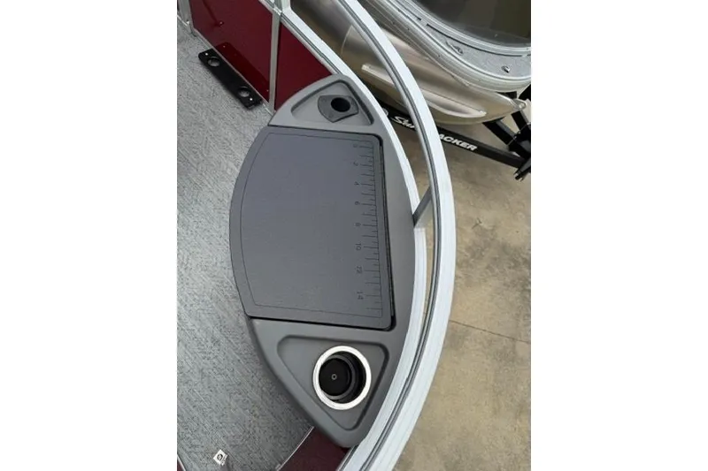 Slide: The Image of 2026 Sun Tracker Bass Buggy 18 DLX boat deck with ruler and cup holder. - 12