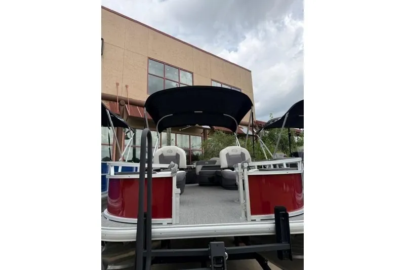 Slide: The Image of 2026 Sun Tracker Bass Buggy 18 DLX pontoon boat with canopy, parked outdoors. - 5