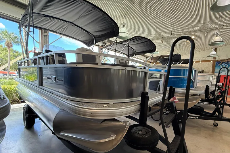 The Image of 2026 Sun Tracker Bass Buggy 18 DLX pontoon boat displayed indoors. - 0